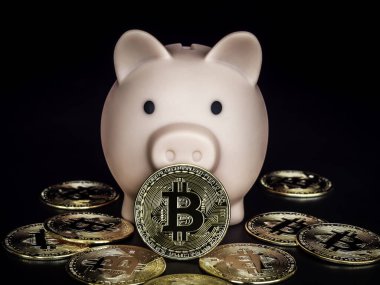 Bitcoin teknolojisi geçmişi. Koyu arka planda pembe kumbarası olan altın bitcoin. Dijital cüzdan, kripto para birimi yatırımının yararları ve tasarruf kavramı.