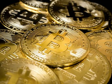 Bitcoin teknolojisi geçmişi. Koyu arka plandaki altın bitcoin yığınını fotokopi alanı ve kripto para yatırımı konseptiyle kapatın. Dijital gelecek para birimi finansal geçmişi.