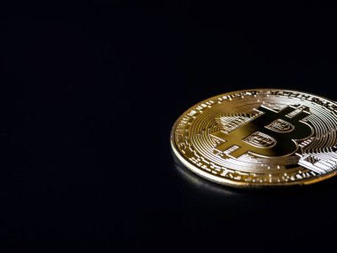 Bitcoin teknolojisi karanlık arka plan. Fotokopi alanı ve kripto para yatırımı konseptiyle siyah arka planda altın bir bitcoin. Dijital gelecek para birimi finansal geçmişi.