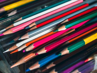 Renkli kalem arka planı. Sanat stüdyosundaki cam masanın üzerine kullanılmış renkli kalemlerle eski renkleri kapat, klasik ton tarzında. Sanat eserleri yapmak için sanatçı araçları.