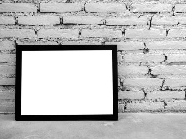 Model fotoğraf çerçevesi. Beton rafta siyah çerçeveli beyaz kare resim ve kopya alanı olan beyaz tuğla duvar arkaplanı.