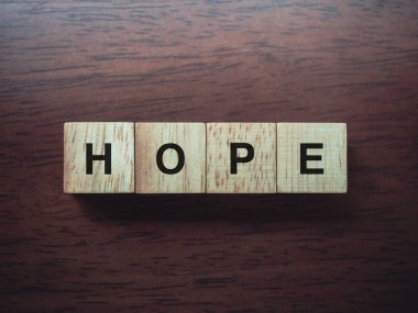Hope, tahta küpler üzerinde kelimeler kahverengi tahta masa arkasında, yakın plan, üst görünüm.