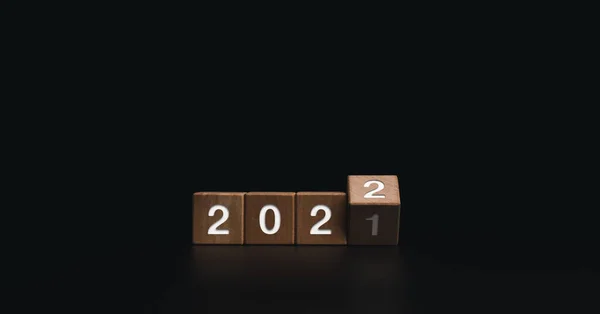 2022年新年快乐欢迎和圣诞快乐横幅 在黑暗背景下翻转木制立方体块 以将2021年改为2022年 — 图库照片