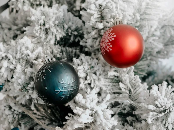クリスマスの背景 白い雪に覆われたモミの木に緑と赤のクリスマスボールの装飾 クローズアップ — ストック写真