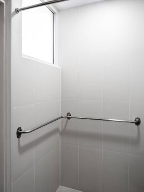 Yaşlı ya da engelli güvenlik desteği için banyoya yerleştirilmiş paslanmaz çelik levye. Erişilebilir banyo kavramı, yaralanma önleme, hasta bakımı ve ev güvenliği modifikasyon tasarımı.