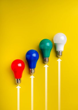 Sarı arka planda yukarı doğru sıralanmış renkli ampuller liderlik, yaratıcılık, yenilik ve teknoloji yarışmasını sembolize ediyor. İş ve başarı kavramları için mükemmel..