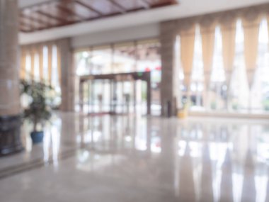 Lüks bir otel lobisinin bulanık arka planı, büyük kapısı, zarif ışıklandırması, mermer zemini ve modern iç mekanı olan giriş alanı. Tasarım modelleri, sunumlar, konukseverlikle ilgili içerik için mükemmel.