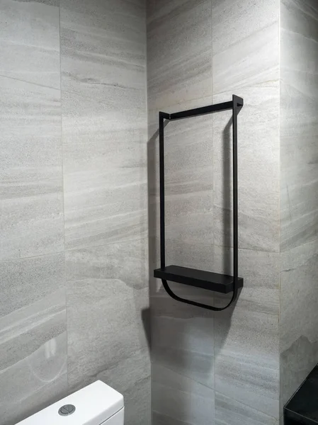 Modern gri duvar fayansları üzerinde minimalist boş siyah metal banyo rafı, ürün modeli, iç tasarım ve banyo depolama konsepti için mükemmel. Ev dekorasyonu ve organizasyon görüntüleri için ideal.