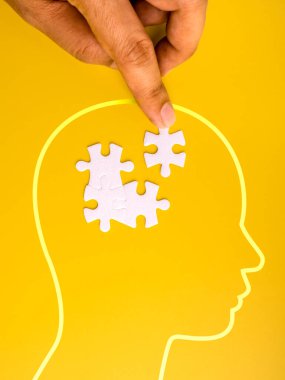 Zihinsel sağlık ve sorun çözme konsepti insan eli ile kafa siluetinin içine yapboz parçası yerleştirmek. Psikoloji terapisi, fikir çözümü, bilişsel düşünce, beyin fonksiyonu ve zihinsel farkındalık..