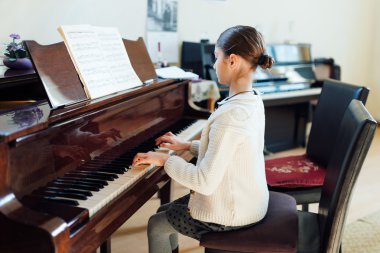 iyi bir öğrenci piyano müzik okulda çalıyor.