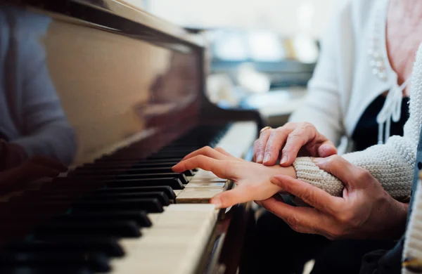 Mão experiente de professor de música antiga ajuda aluno criança — Fotografia de Stock