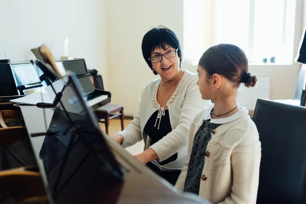 Učitel hudby vysvětluje škodolibě, jak hrát na klavír — Stock fotografie