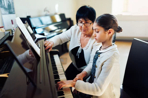 Musiklärare med eleven på lektion piano — Stockfoto