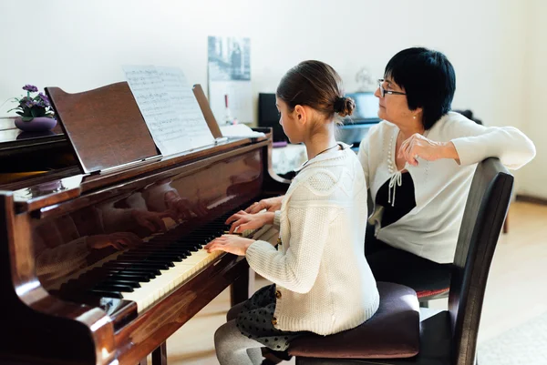 Musiklärare med eleven på lektion piano — Stockfoto