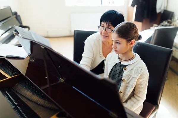 Musiklärare med eleven på lektion piano — Stockfoto