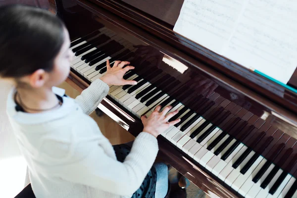 Buen estudiante toca el piano en una escuela de música — Foto de Stock