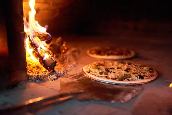 Pizza cruda stendere stufa con il fuoco sulla lama . — Foto Stock