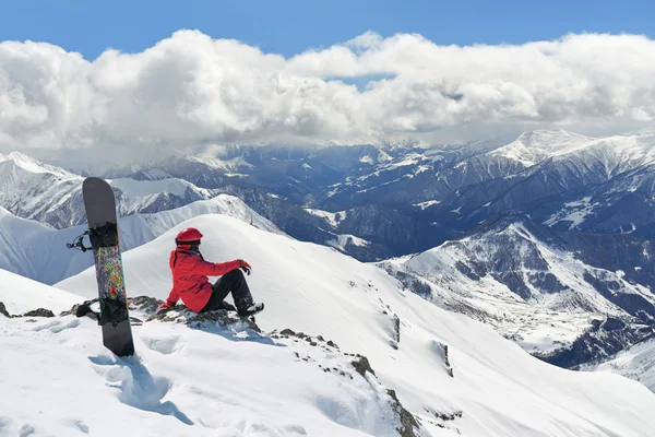 Сноубордист, сидящий на краю горы — стоковое фото