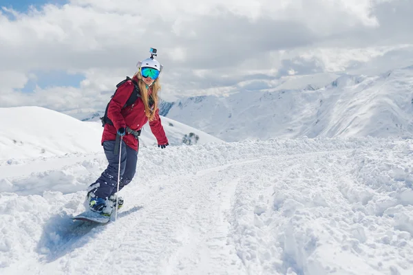 Fille snowboarder chevauche un snowboard remorqué tenant la corde . — Photo