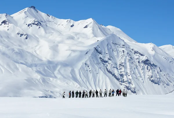 Gran grupo de personas de lejos en las montañas en invierno —  Fotos de Stock