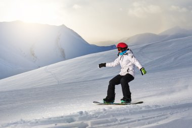 Kız snowboard yokuş aşağı gidiyor  