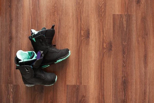 boş alanı olan ahşap zemin üzerinde siyah snowboard botları
