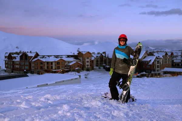 Hübsche Snowboarderin steht vor Hotel-Skigebiet — Stockfoto