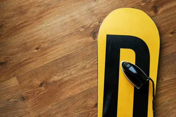 Plancha sobre una cera de snowboard, suelo de madera tumbado — Foto de Stock
