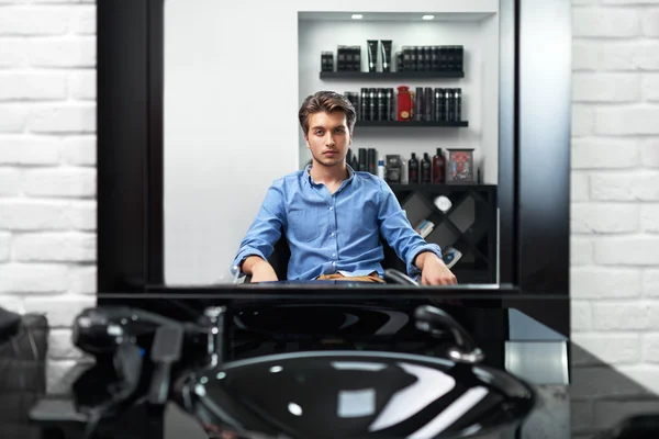 Hombre se mira en el espejo Barbería —  Fotos de Stock