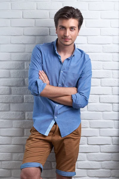 Man is staying on the brick background in the studio — Stock Photo, Image