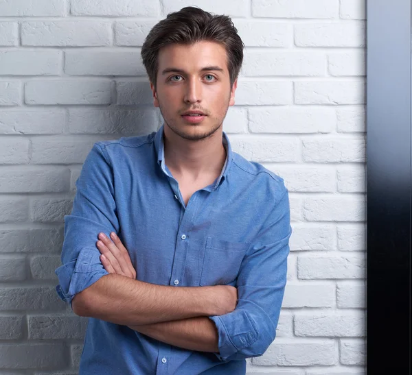 Man is staying on the brick background in the studio — Stock Photo, Image
