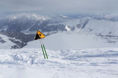 keskin bir uçurum uyarı, karlı dağlarda ayakta etiket.