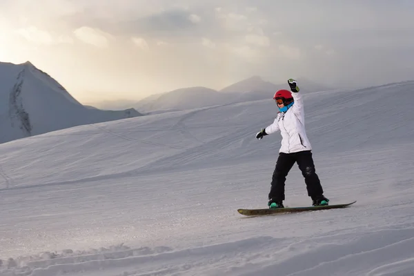 Meisje snowboarder rijdt helling af — Stockfoto