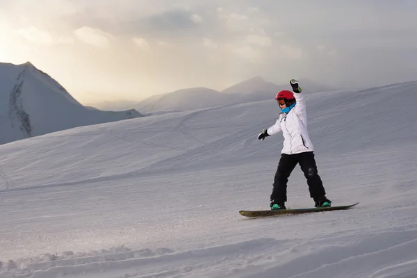 여자의 snowboarder 경사면 아래로 타기 — 스톡 사진