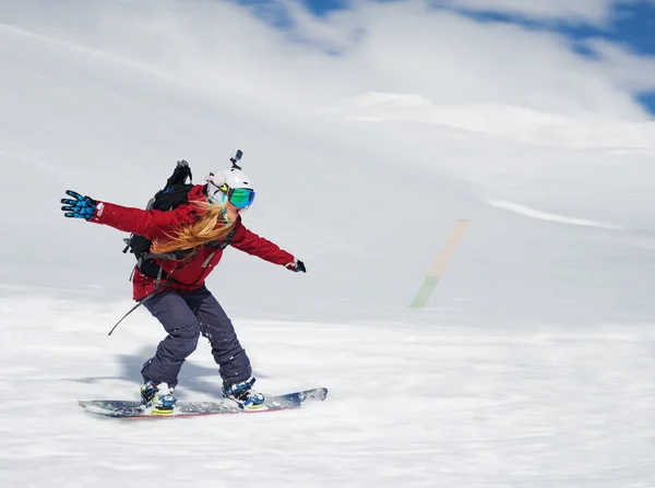 Chica snowboarder va rápidamente por la pendiente y grita — Foto de Stock