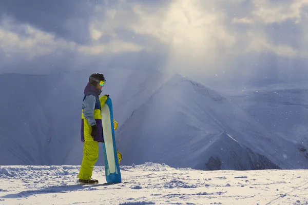 Tempo nevado nas montanhas snowboarder fica de lado — Fotografia de Stock