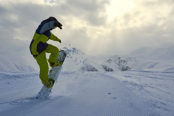 Snowboarder macht den Trick und hebt die Vorderseite des Brettes. — Stockfoto