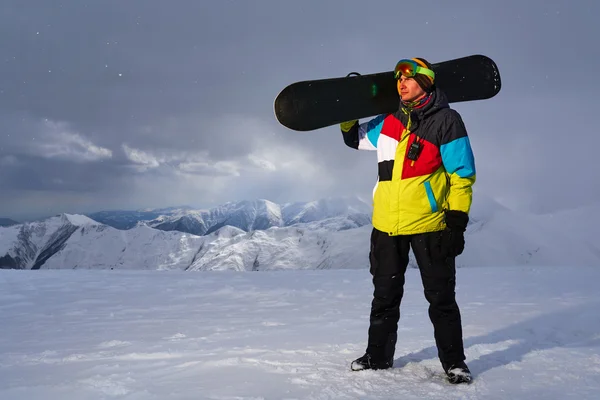 Snowboarder trägt ein Snowboard in der Hand. — Stockfoto