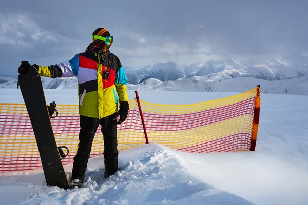 Snowboarder ao lado da segurança da grade de partição — Fotografia de Stock