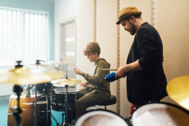 Öğretmen bir çocuk için davul dersi veriyor..