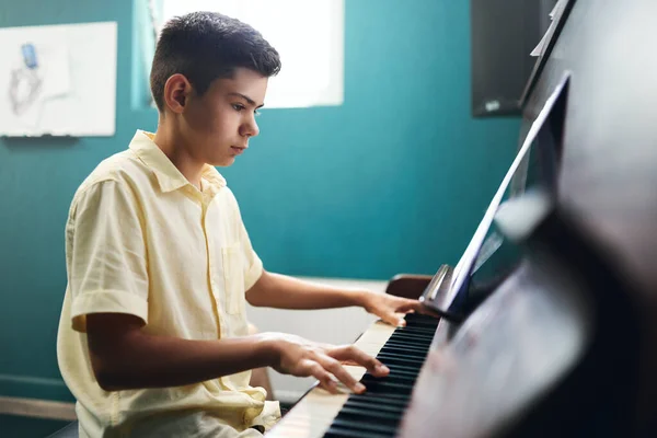 Συγκεντρωμένο αγόρι μαθαίνει να παίζει πιάνο. — Φωτογραφία Αρχείου