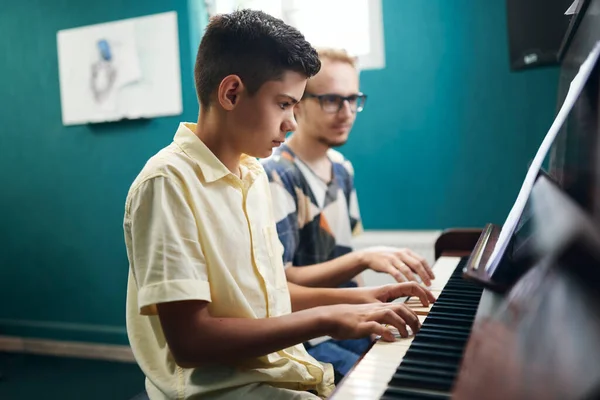 Αγόρι μαθαίνει να παίζει πιάνο με δάσκαλο — Φωτογραφία Αρχείου