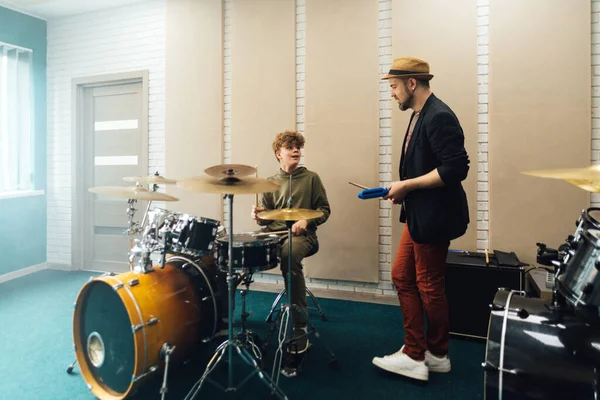 The teacher explains to the boy how to play the drums. Music school. — Stock Photo, Image