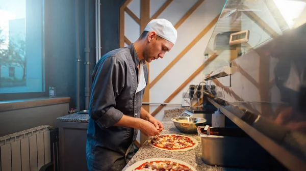 Lo chef sta cucinando la pizza. Lavori di ristorazione cucina. — Foto Stock