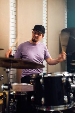 Adam davul setini çok canlı çalıyor. Müzik enstrümanları çalmak.