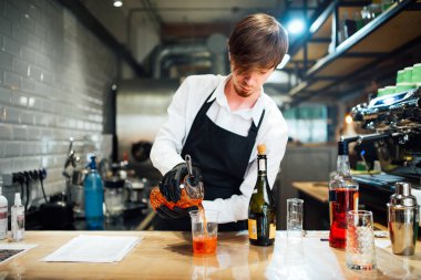 Barmen bardağa kokteyl doldurur. İçme hazırlama süreci.