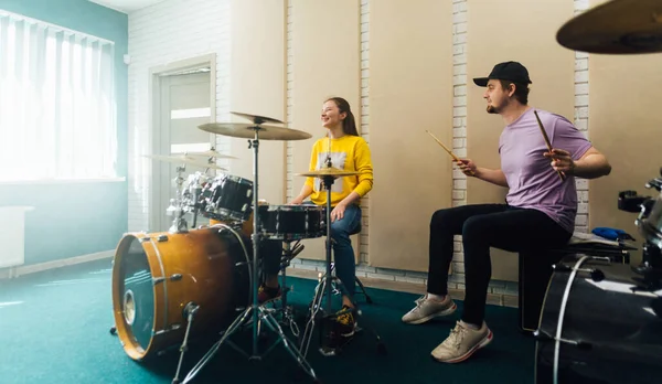 若い女性を示す男性教師ドラムを再生する方法. — ストック写真