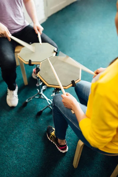 Två personer sitter mittemot varandra och spelar trummor. Spela övningsdynorna. — Stockfoto