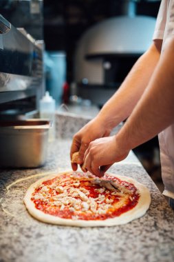 Şef pizzanın içeriğini belirler. Mutfak işleri..