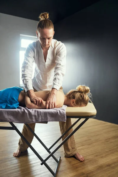 Masseur gibt junge Frau eine Armmassage. Heilende osteopathische Körpermassage. — Stockfoto